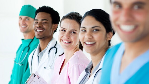 five health care professionals smiling standing in a line