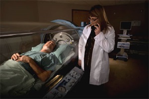 Physician watching a patient going through hyperbaric oxygen therapy