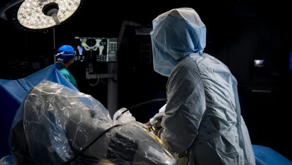 Surgeon in operating room using a robot