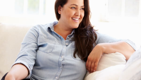 a woman sitting on her couch smiling