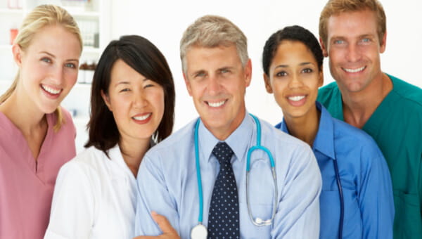 a team of clinical workers standing next to each other smiling