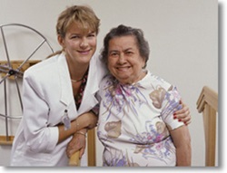 Female social worker in white coat, standing with female patient