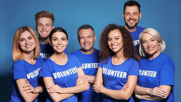 a group of men and women wearing blue volunteer shirts