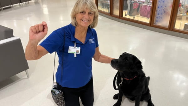 A volunteer poses with her therapy dog at St. Anthony's Hospital