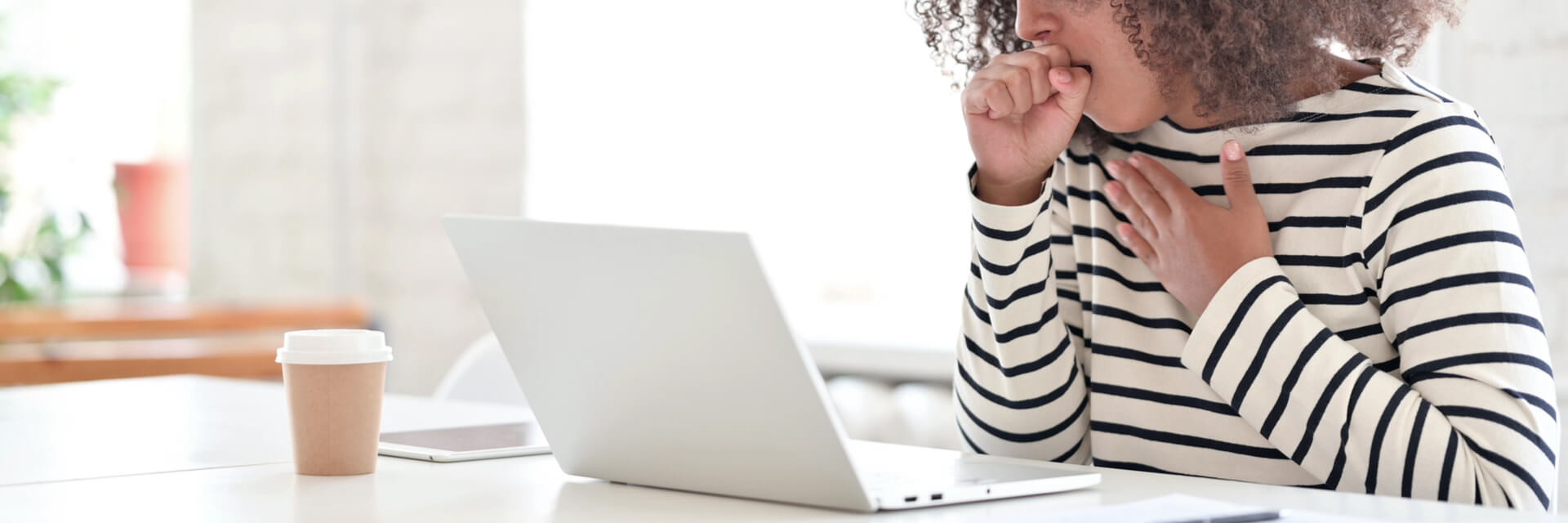A woman uses an online symptom checker on her laptop.