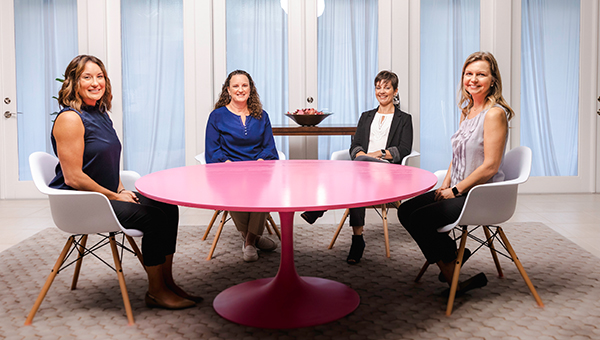 four ladies sitting around a pink table