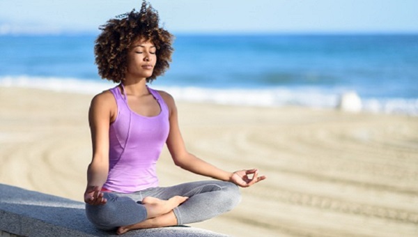 woman meditating on the beach mental wellness integrative medicine