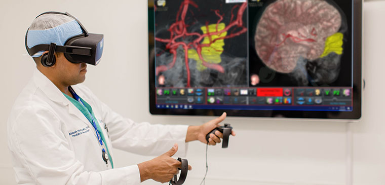 A surgeon wears a virtual reality headset and uses hand controls