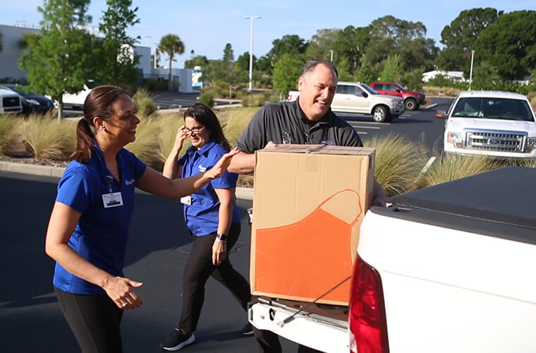 Group of volunteers packs truck full of boxes to send to senior community