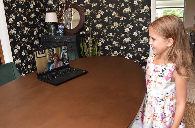 Ellie York speaks remotely with a woman whose image is on a computer screen.