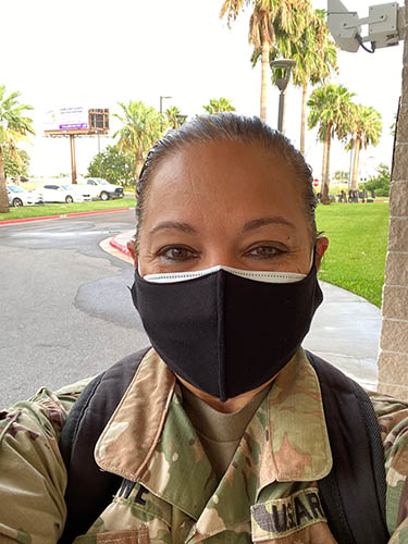 Kathy Lowe wearing fatigues and a mask