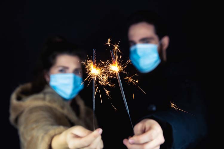 A masked man and woman holding sparklers