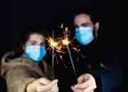 A masked man and woman holding sparklers