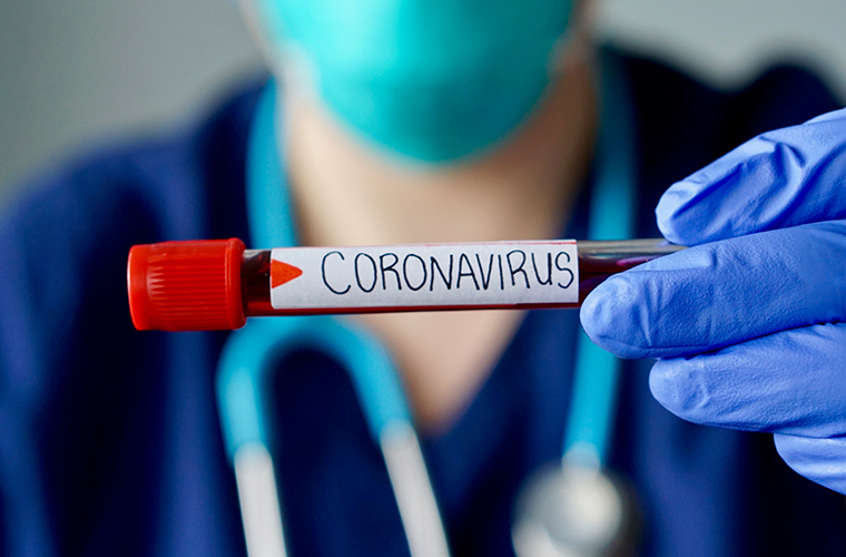 medical professional holding a blood test labeled coronavirus