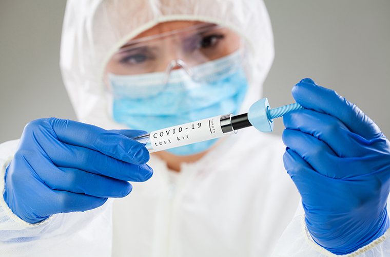 Medical professional wearing blue gloves and working with a antigen test