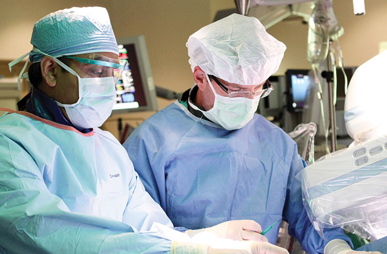 Alok Singh, M.D., (left) and Andrew Sherman, M.D., collaborate during a cardiac procedure. Dr. Singh is Chair of St. Joseph's Hospital's Cardiology program and Dr. Sherman is Chair of St. Joseph's Hospital's Cardiovascular Surgery program