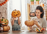 Child and mother decorating Halloween pumpkins