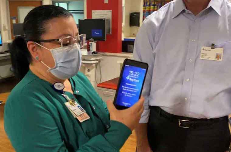 A nurse holding the PatientTouch device