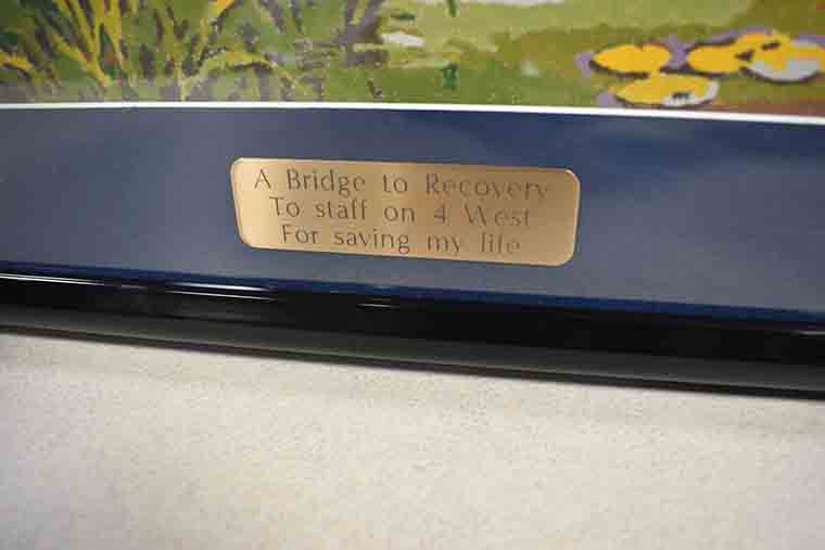 Inscription plate on painting reading: A Bridge to Recovery. To staff on 4 West for saving my life.