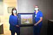 Nurses Lisa Cotroneo and Bridget Farnsworth hold Robert Sakoff's painting