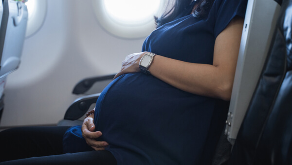pregnant woman sitting in an airplane seat