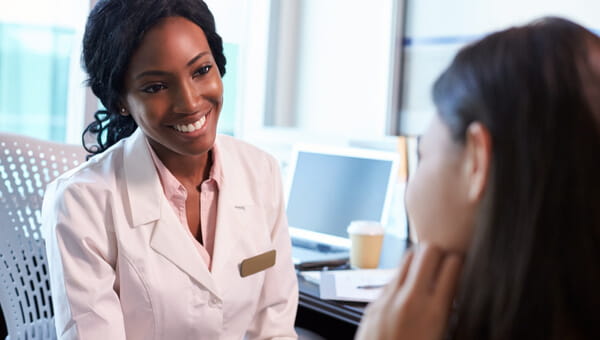 smiling doctor sitting across from woman
