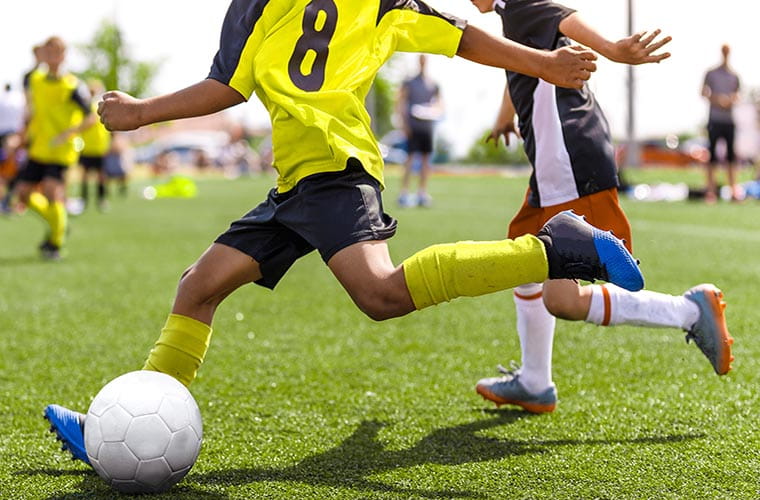 Kids playing soccer on field