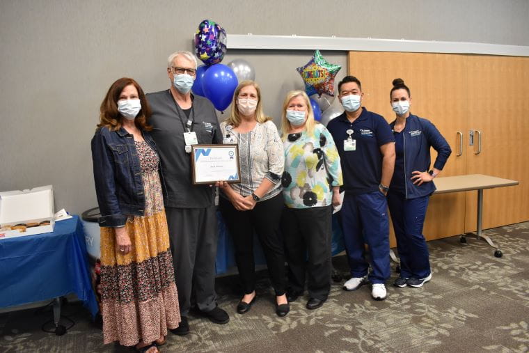 Jack holding his plaque among a group of BayCare and St. Joseph's Hospital-South administrators and team members.