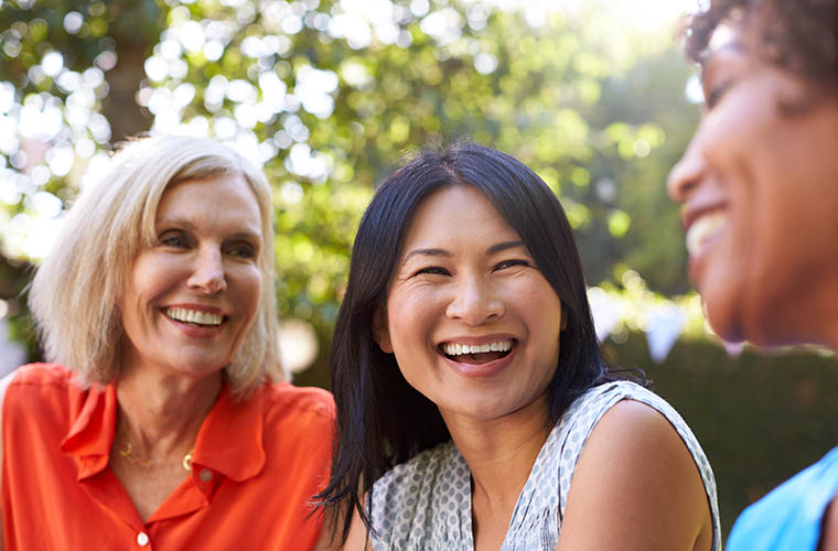 Three women socializing outdoors 