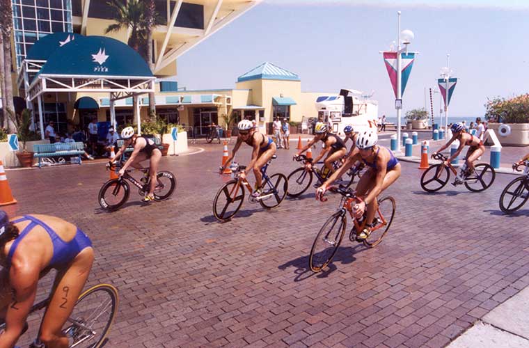 Athletes bike past the old St. Petersburg Pier.