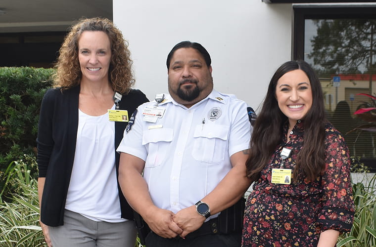 Proud grandfather Eleuterio stands between two female physicians who were part of his family's care team.