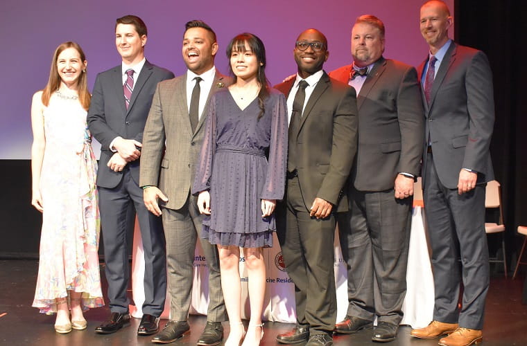 The newly-minted family medicine physicians of The Florida State University College of Medicine Family Medicine Residency at BayCare graduated on June 17 in Winter Haven at the historic Ritz Theater. From left: Dr. Ashley Wilk; Dr. Trevor Owens; Dr. Ravi Patel; Dr. Dianna Pham; Dr. Marvin Dieujuste; Dr. Brian Greene and Dr. Nathan Falk.