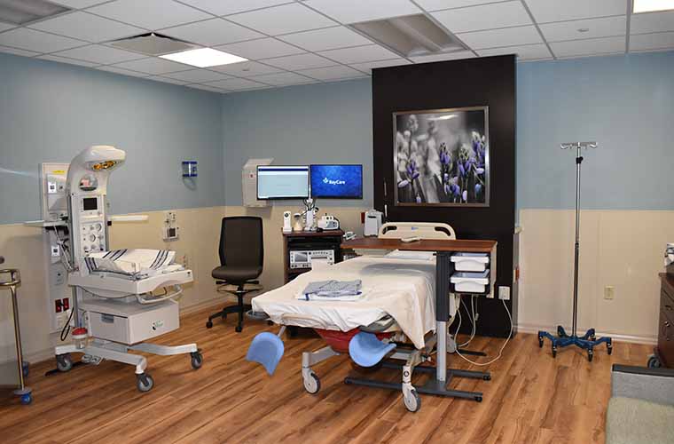 A new labor and delivery room. Includes a hospital bed with stirrups, an infant warmer and monitors.