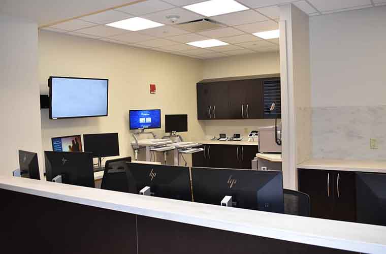 Additional nursing administration workspace. Includes desk area, nine computer stations and three storage cabinets.