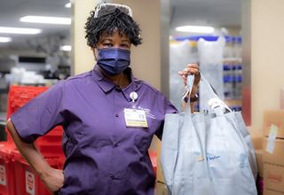 A BayCare team member displays the Healing Bag of food given to patients in need.