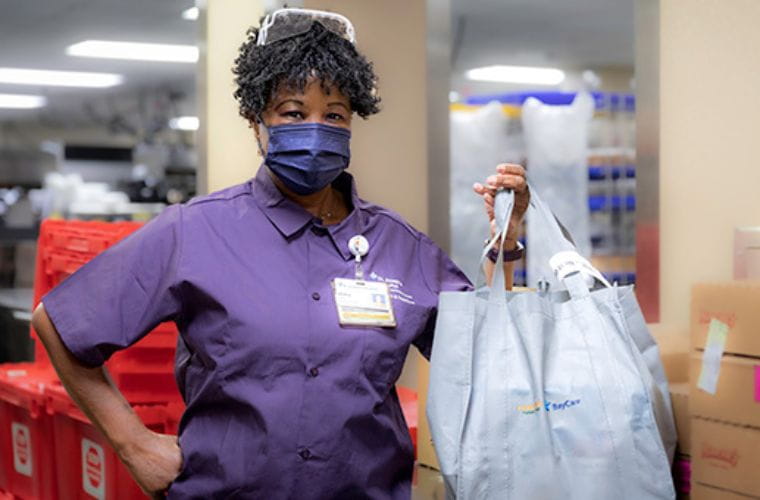 A BayCare team member displays the Healing Bag of food given to patients in need.