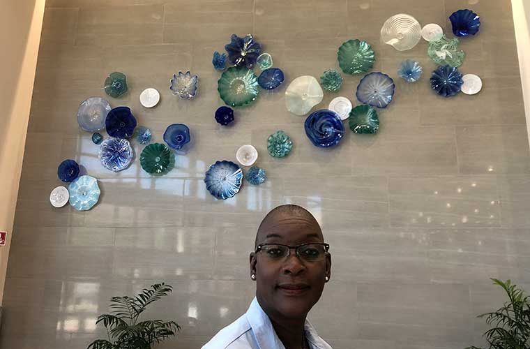 Woman smiling in lobby of hospital.