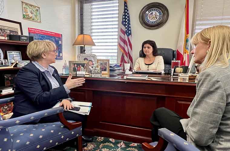 Two BayCare leaders talk with an elected official in their Tallahassee office.