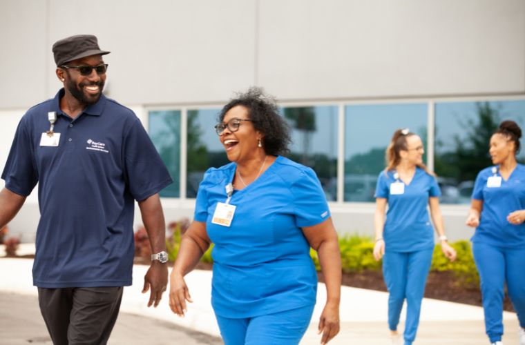 A group of people walking in blue scrubs and health care uniforms.