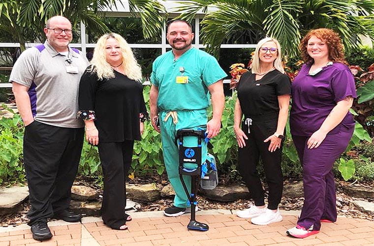 Five people standing in varying medical apparel.