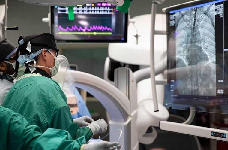 A group of doctors, nurses and technicians perform a heart procedure on a patient in an operating room at Morton Plant Hospital in Clearwater, Florida.