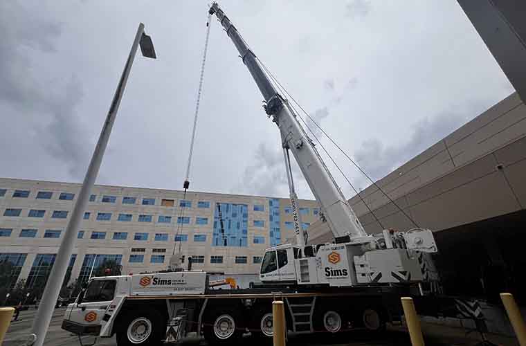 A construction crane rises high above the hospital with the hospital in the background. 
