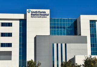 An exterior building shot of a hospital. The words South Florida Baptist Hospital and BayCare Health System underneath it appears on one of the buildings, along with the BayCare logo.  