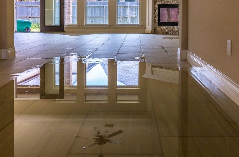 Interior view of an empty home showing a flooded tile floor.