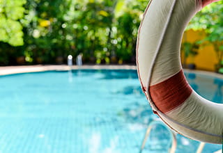 Lifebuoy hanging on a wooden beam at the pool