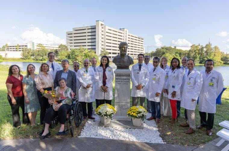 Members of the Maniscalco family and BayCare leaders gather around a bust of Hippocrates outside BayCare’s Academic Health and Research Corridor.