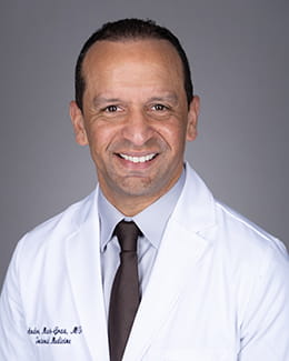 Dr. Andres Marte- Grau's headshot wearing a lab coat