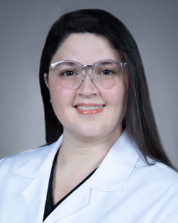 Dr. Roman's headshot wearing a lab coat 