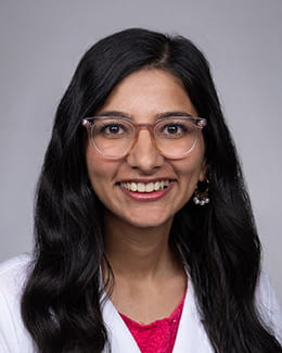 Isha Jhingan's headshot in a lab coat