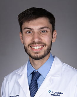 Neal Malhotra's headshot in a lab coat